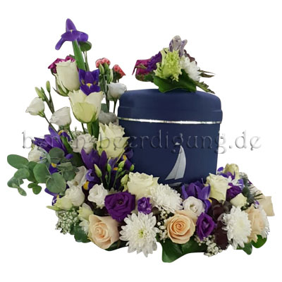 Dieser weiß-blaue Urnenkranz wird aus weißen und cremefarbenen Rosen, Lysianthus, Chrysanthemen und Iris gesteckt. Mit Urnenhäubchen aus Blumen.