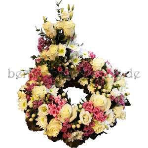 Blumenkranz mit erhöhtem Teilgesteck aus weißen Rosen, weißen Chrysanthemen, rosa Bouvardien, Lysianthus und Johanniskrautbeeren